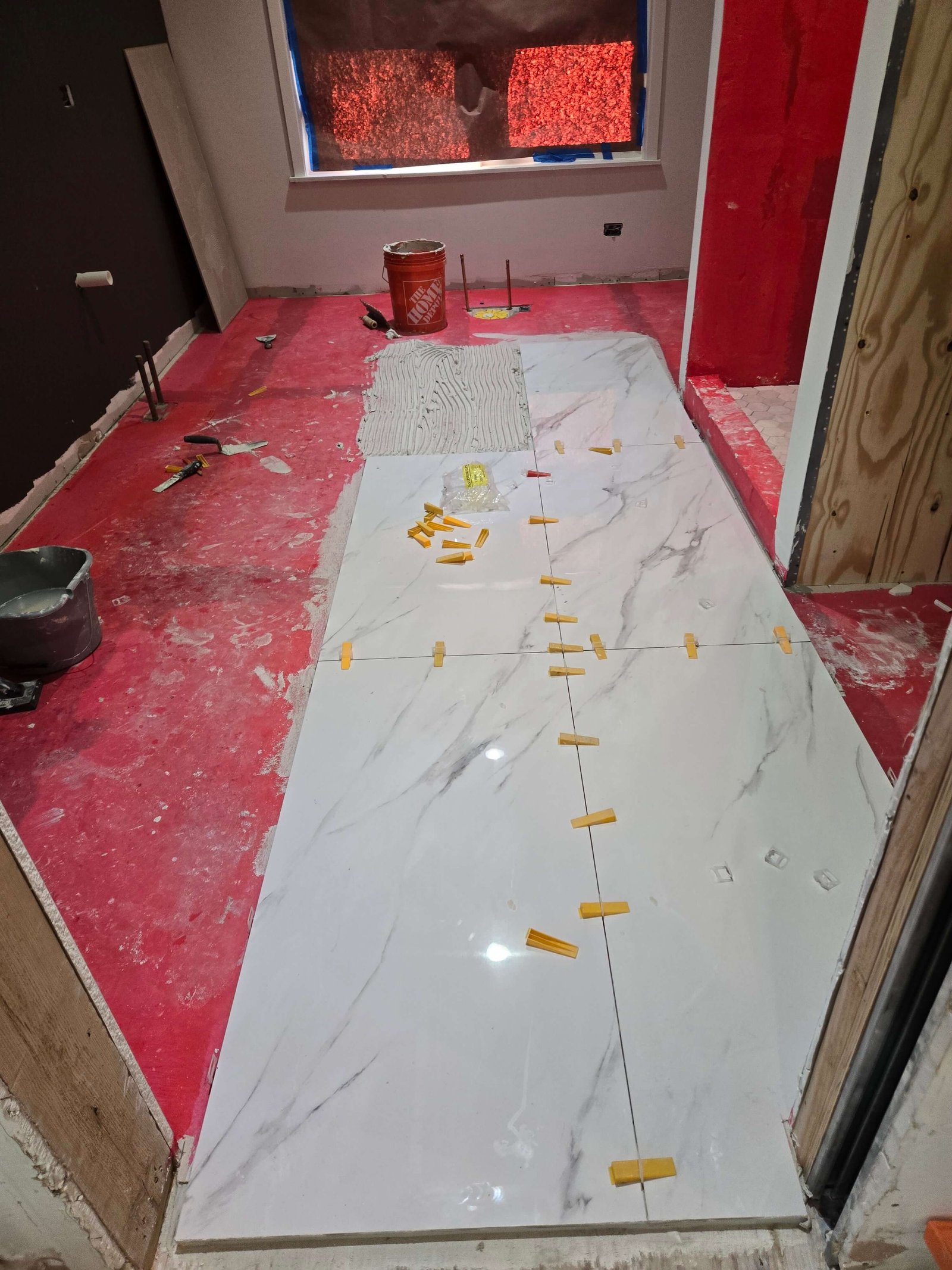 Bathroom marble-look floor tile installation in progress