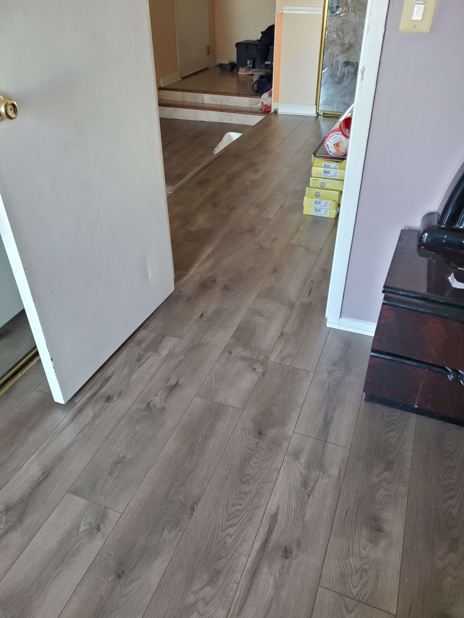Hardwood flooring installed through hallway and adjoining rooms